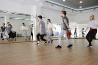 A group of four young modern dancers dancing in a studio.